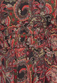 Tkanina s květinovým vzorem v odstínech červené, zelené a černé. Lehká, s nařaseným pasem a měkkou texturou, která ukazuje složité vzory.