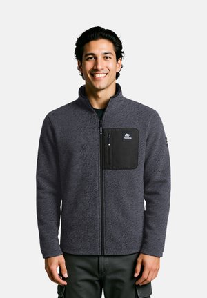 Grau Fleecejacke mit hohem Kragen, Reißverschluss vorne und einer schwarzen Brusttasche. Der Stoff hat eine strukturierte Oberfläche.