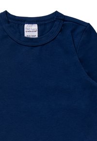 Maglietta a maniche lunghe di colore blu navy, realizzata in cotone e con colletto a girocollo. Include un'etichetta all'interno del collo che indica il marchio e i dettagli della taglia.