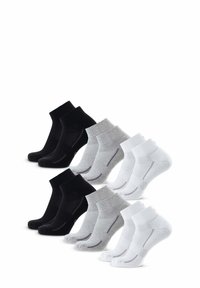 Tres pares de calcetines: uno negro, uno gris y uno blanco. Cada uno presenta un puño acanalado, una puntera reforzada y un sutil detalle de costura.