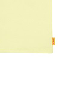 Tessuto giallo brillante con una trama texture, caratterizzato da un orlo cucito e un piccolo etichetta arancione nell'angolo in basso a destra.