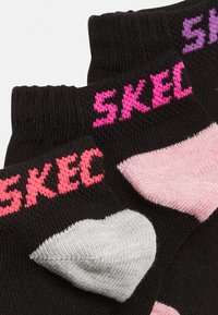 Sorte sokker med pink og lilla "SKEC" tekst. Har hjerteformede mønstre i pink og grå. Lavet af blødt, elastisk stof.