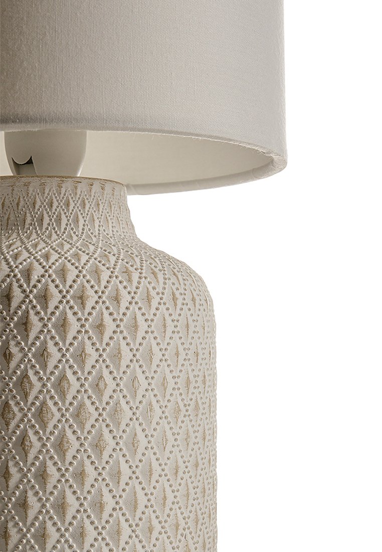 Krémová stolní lampa s texturovaným diamantovým vzorem na keramickém podstavci, zakončená bílým tkaninovým stínidlem.