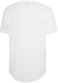 T-shirt en coton blanc à col rond et manches courtes. Le dos est uni, avec un ourlet légèrement courbé.