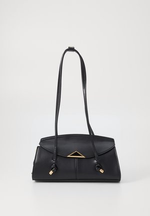 Černá kožená kabelka přes rameno s dlouhými tenkými pásky, trojúhelníkovým zlatým detailem na klopě a konci pásků zakončených zlatými uzlíky.
