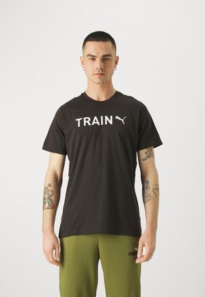 Czarna bawełniana koszulka z krótkim rękawem z białym napisem "TRAIN" i logo Puma na piersi. Posiada okrągły dekolt i gładką fakturę.