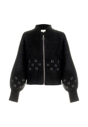 Svart kort cardigan laget av fluffy stoff, med glidelås, høy krage og ballongerm som har et subtilt logomønster i grått.