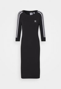 Vestido negro de longitud a la rodilla hecho de algodón, con tres rayas verticales blancas en las mangas y un pequeño logo blanco en el pecho.