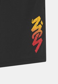 Pantaloni sportivi neri con una grafica a gradiente crepolato che va dal giallo al rosso. Questi pantaloni hanno una texture liscia e una vestibilità comoda.