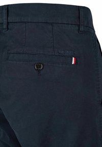 Navyblauwe broek van duurzaam materiaal heeft een achterzak met een zwarte knoop en een kleine driekleurige accent. Merkennaam "HECHTER" is reliëf aangebracht.