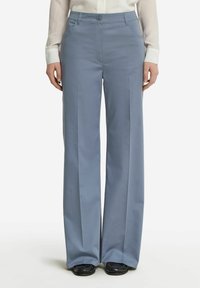 Ljusblå vida byxor gjorda av mjukt tyg, med knäppning, framfickor och en skräddarsydd silhuett.