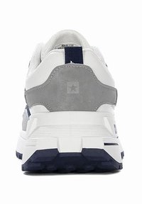 Białe i szare sneakersy z wyprofilowanym piętem, teksturowanym zamszem i granatową podeszwą. Posiadają logo z tyłu oraz paskowe detale.