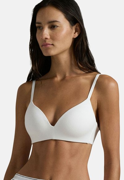 Bralette bianco con una texture liscia e a coste, dotata di spalline regolabili, scollatura profonda e un design aderente.