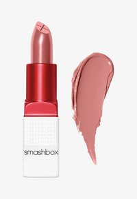Rouge à lèvres de Smashbox dans un tube rouge élégant avec des accents blancs. La teinte présentée est un rose doux, accompagnée d'un échantillon de la même couleur.