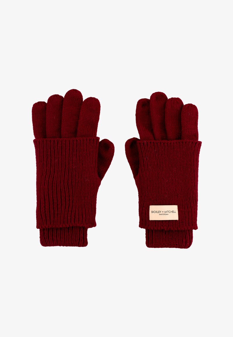 Gebreide vingerloze handschoenen in diep rood met ribbelstructuur. Beschikt over een leren label met het merk "Bickley + Mitchell".