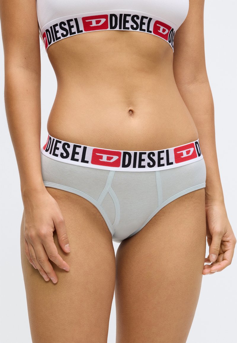 Hellblaue Baumwoll-Slip mit einem weißen und schwarzen elastischen Bund mit dem "DIESEL"-Logo. Glatte Textur, klassisches Design und mittelhoher Bund.