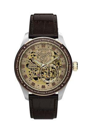 Analóg Timex karóra Hogwarts címerrel, átlátszó arany fogaskerekekkel, barna bőrszíjjal és a "Hogwarts School of Witchcraft and Wizardry" felirattal.