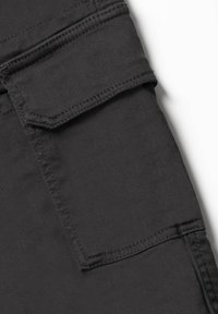 Zwarte stoffen cargozak met opgevouwen klep, zichtbare stiksels en een gladde textuur. Beschikt over een rechthoekige vorm voor functionaliteit.