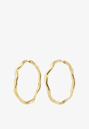 Un paio di orecchini a cerchio irregolari in oro con un design lucido e ondulato e chiusure a cerniera su uno sfondo bianco.