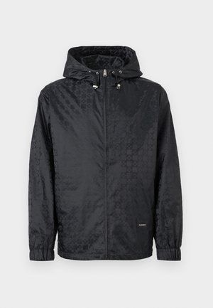 Zwarte capuchonjas met subtiel ruitpatroon, ritssluiting aan de voorkant, elastische manchetten en verstelbare trekkoorden in de capuchon.