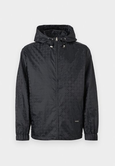 Μαύρο μπουφάν με κουκούλα και διακριτικό καρό μοτίβο, εμπρός φερμουάρ, ελαστικά μανίκια και ρυθμιζόμενα κορδόνια στην κουκούλα.