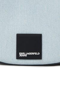 Világoskék farmeranyag, fekete téglalap alakú folttal, rajta fehér szöveggel: "KARL LAGERFELD JEANS." Simább textúra és egyszerű dizájn.