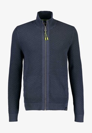 Pull zippé en maille texturée bleu marine, col montant, poignets et ourlet côtelés, avec tirettes de fermeture éclair accentuées de jaune néon.