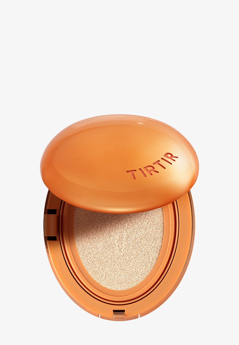 Round compact with a glossy orange lid, featuring the embossed brand name. Inside, a sponge applicator sits atop a beige cushion.