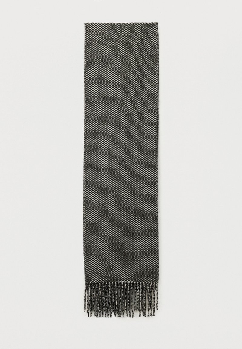 Cachecol tecido de um cinza escuro com um padrão fino e franjas torcidas numa das extremidades, exibido plano sobre um fundo branco.
