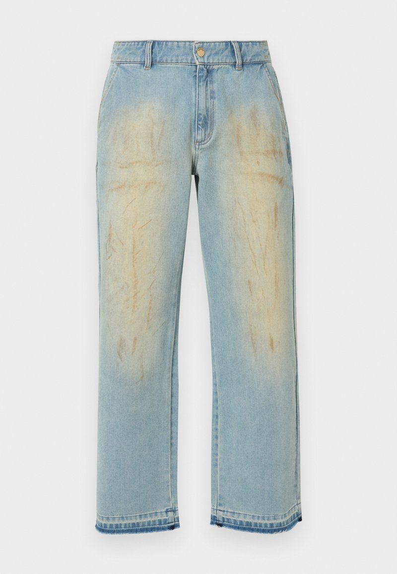 Jean bleu clair coupe droite avec des patchs beige délavés et usés sur les cuisses, les poches avant, les passants de ceinture et la fermeture par bouton.