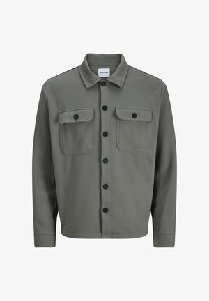 Veste en tissu tissé gris avec un devant à boutons, deux poches poitrine avec rabats et un col classique. Des boutons noirs accentuent le contraste.