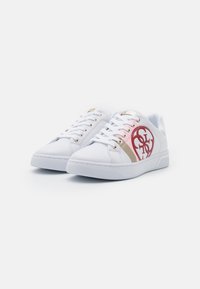 Sneakers bianchi con accenti rosa e oro, dotati di un logo circolare, design con lacci, suola in gomma e superiore in materiale sintetico liscio.