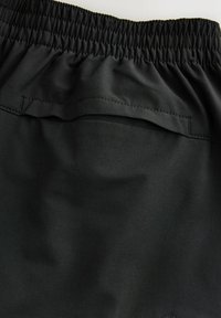 Black athletic shorts with an elastic waistband, featuring a back pocket and smooth, moisture-wicking fabric texture.