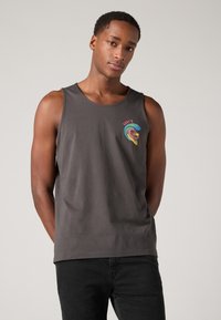 Débardeur en coton gris avec un col rond, présentant un graphique coloré du logo Levi's sur la poitrine gauche. Design simple et sans ornements.