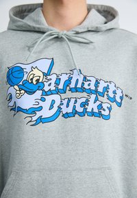 Un sweat à capuche gris arborant un grand graphique bleu et blanc représentant un canard de dessin animé tenant un basket-ball avec le texte « Oregon Ducks » en lettres majuscules.