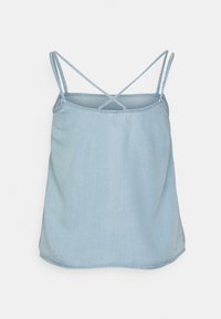 Camisola de ganga azul clara com alças finas em forma de cruz, ajuste solto e textura suave. Barra reta com costura limpa.