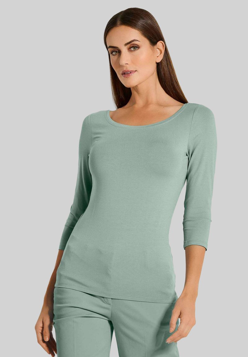 Mintgroene, nauwsluitende top met lange mouwen in ribbelstof met een ronde halslijn. Gecombineerd met bijpassende broek, met een gladde textuur en zonder zichtbare patronen.