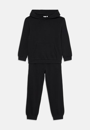 Fekete gyerekeknek készült, kapucnis, hosszú ujjú pulóverből álló két részes szett, elülső zsebbel és illeszkedő gumis szárú melegítőnadrággal.