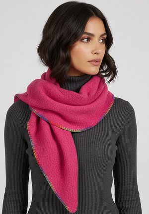 Woman with shoulder-length dark hair wearing a dark gray ribbed turtleneck and bright pink wool scarf with multicolor stitched edges.