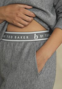 Loungewear gris texturé en tissu tricoté doux, avec une taille arborant l'inscription "b par Ted Baker" en gris et blanc contrasté, et des poches latérales.