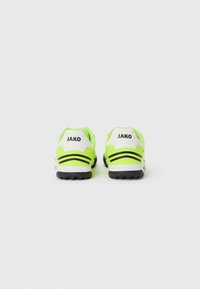 Baskets de sport vert fluo avec des rayures noires, talon blanc, semelle en caoutchouc texturée et marquage "JAKO" au dos. Design léger.