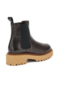 Botín Chelsea de cuero marrón con paneles elásticos laterales, suela de goma y costuras marrones texturizadas; cuenta con una plataforma gruesa y estriada en beige.