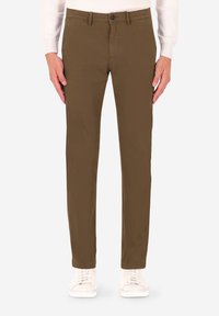 Pantaloni di cotone marroni con taglio dritto, con chiusura a bottone e tasche frontali, abbinati a sneakers bianche.