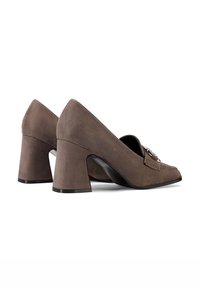 Scarpe con tacco a blocco in suede marrone con punta appuntita, caratterizzate da righe orizzontali e un dettaglio decorativo con fibbia sulla parte superiore.