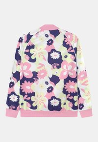 Blommönstrad jacka med livfulla rosa, gröna och marinblå färger. Slätt tyg med ribbade rosa manschetter och krage. Bakvy visas.