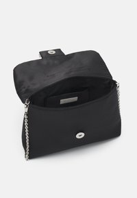 Czarna satynowa kopertówka z srebrnym łańcuszkiem. Posiada magnetyczne zapięcie i małą wewnętrzną kieszeń. Gładka tekstura z minimalnymi akcentami.