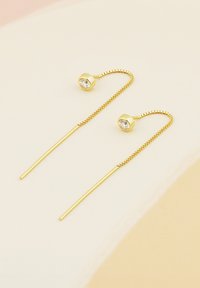 Orecchini dorati caratterizzati da un design elegante con un gancio curvo, adornati da uno strass trasparente sulla parte superiore e un lungo e sottile perno.