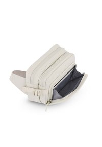 Sac banane beige compact avec deux compartiments zippés, un ouvert montrant l'intérieur en tissu gris et une sangle réglable avec boucle.