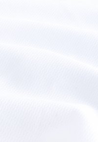 Tessuto bianco testurizzato con sottili costine, che mostra una superficie liscia e una finitura morbida, piegato in onde delicate.