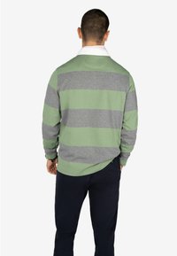 Lange mouwen, gestreepte pullover in lichtgroen en grijs katoen. Heeft een witte kraag en een losse pasvorm met een ronde onderzoom.